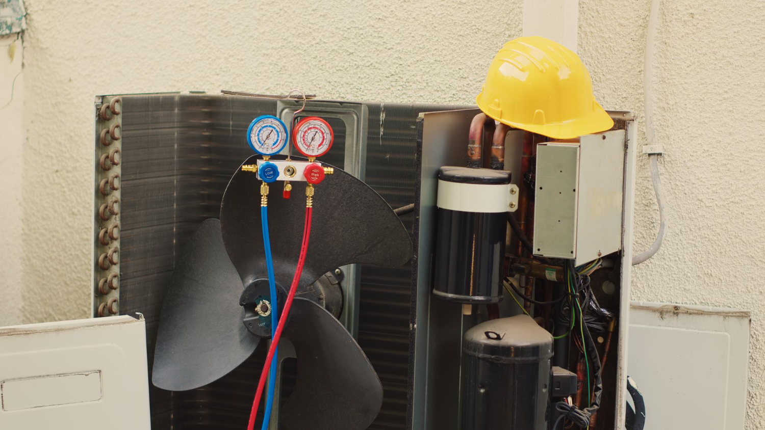 HVAC system components including pressure gauges, fan, and a yellow hard hat, illustrating maintenance and repair tasks for home comfort in Brookfield.